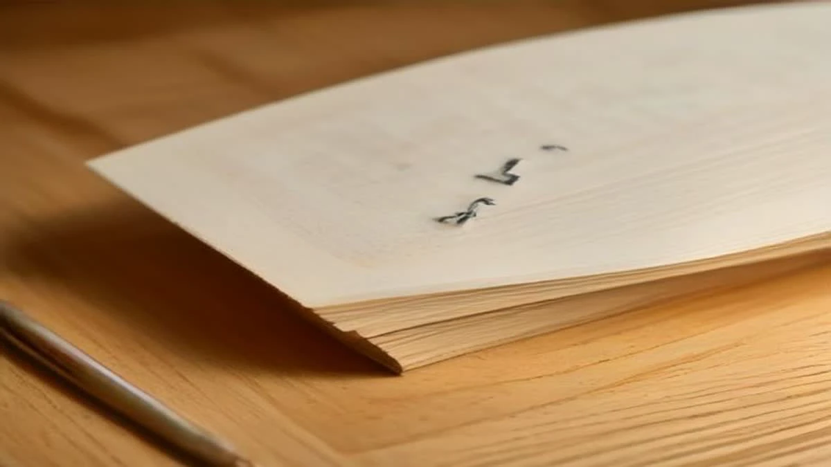 wide establishing shot of a close-up of a spreadsheet printout and a pen on a wooden desk